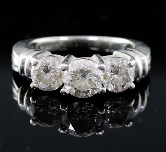A modern platinum and three stone diamond set ring, size L.